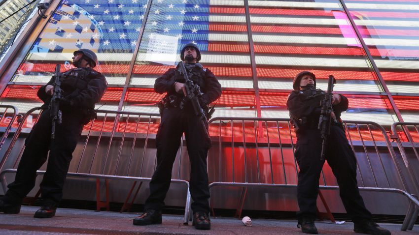 Heavily armed New York city police officers with the Strategic Response Group stand guard at the armed forces recruiting center in New York's Times Square, Saturday, Nov. 14, 2015.  Police in New York say they've deployed extra units to crowded areas of the city "out of an abundance of caution" in the wake of the attacks in Paris, France. A New York Police Department statement released Friday stressed police have "no indication that the attack has any nexus to New York City." (AP Photo/Mary Altaffer)