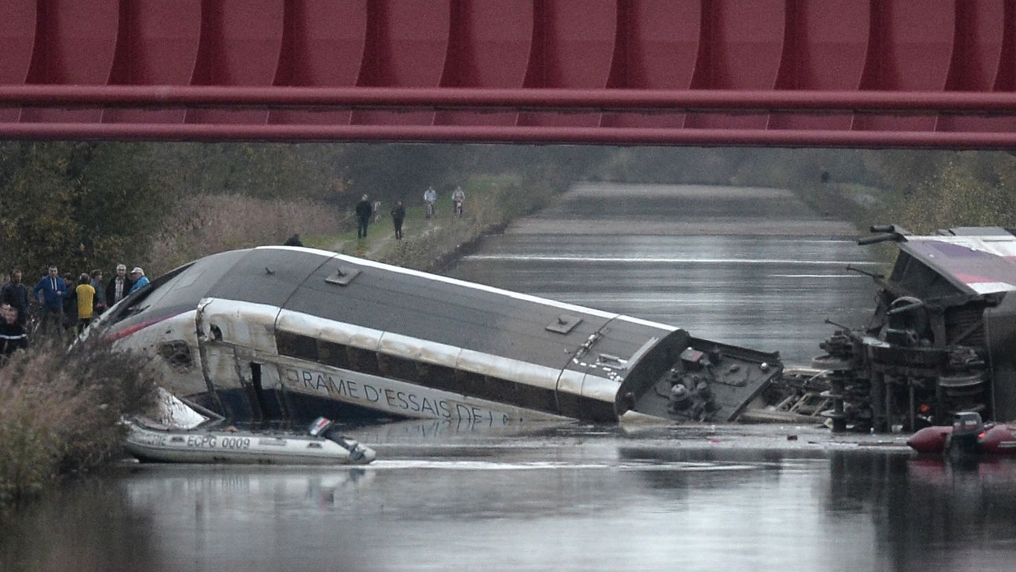 Rescuers arrive at the scene where a high-speed train derailed and crashed into a canal in eastern France on Saturday.