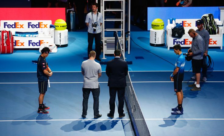 Novak Djokovic (R) of Serbia and Kei Nishikori of Japan observe a minute's silence before their group stage match at the ATP World Tour Finals in London.  