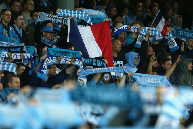 Sydney FC fans hold up a French flag during a moments silence for victims of the Paris terror attacks prior to their team's A-League football match against Melbourne Victory.