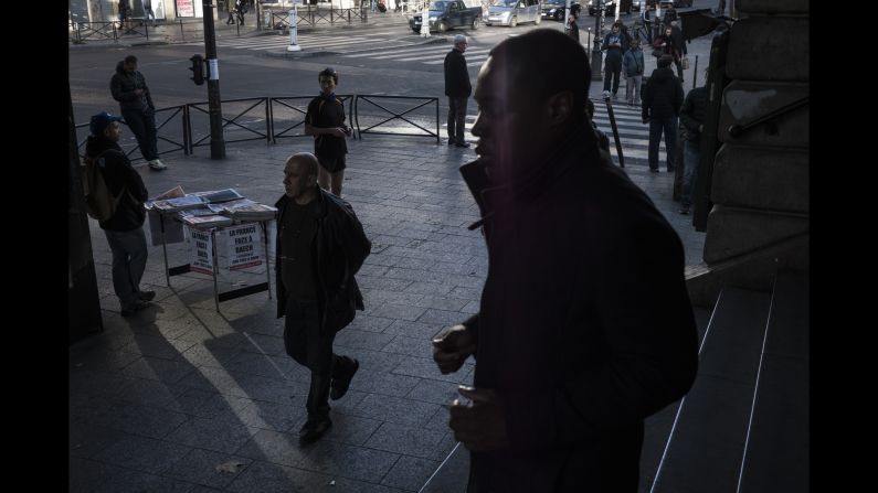 A man sells newspapers on Sunday, November 15, at the Barbes-Rochechouart Metro station in one of the Paris neighborhoods with the highest foreign-born population. The headlines read "The War against Daech / ISIS" and "The Day After." 