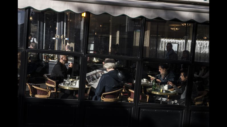 A woman reads a newspaper in the Cafe Les Deux Magots on November 15 In the St. Germain neighborhood of Paris.