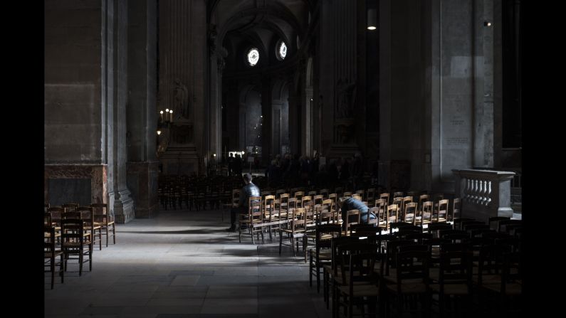 People sit inside the St. Sulpice Catholic church on November 15 in Paris. 