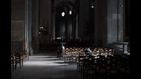 People sit inside the St. Sulpice Catholic church on November 15 in Paris. 