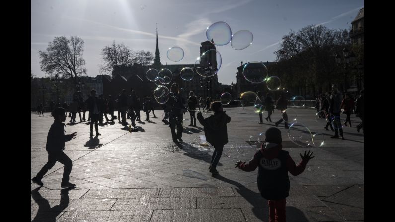 Children play on November 15 with Notre Dame in the background.