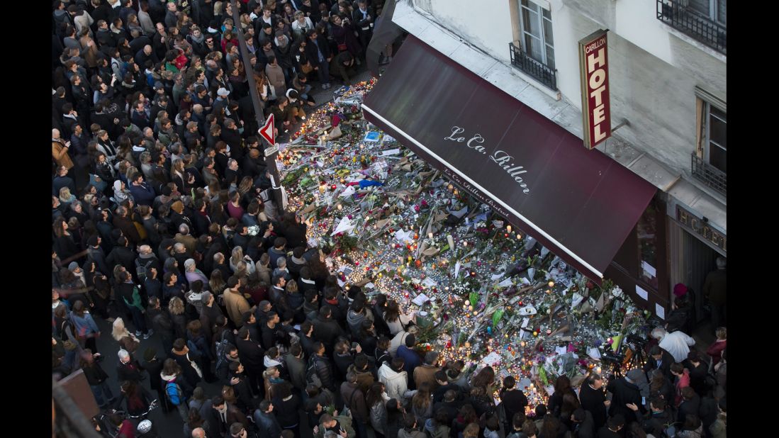 A large crowd gathers to lay flowers and candles in front of the Carillon restaurant in Paris on Sunday, November 15. 