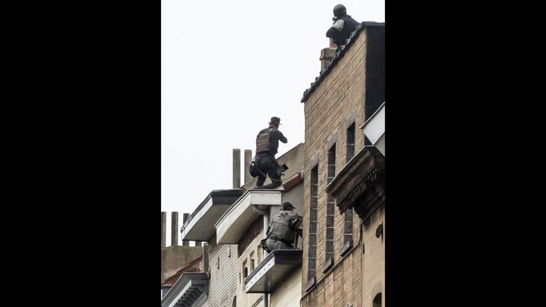 Special forces sit on a roof in Molenbeek as they prepare to enter a house on November 16.