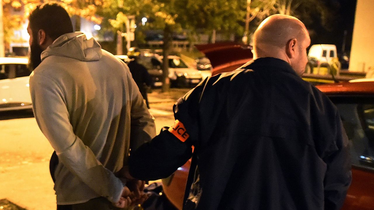 A man is detained by a police officer after a raid in the Mirail district of Toulouse, France, on November 16. French Prime Minister Manuel Valls said there were 150 police raids overnight in the country.