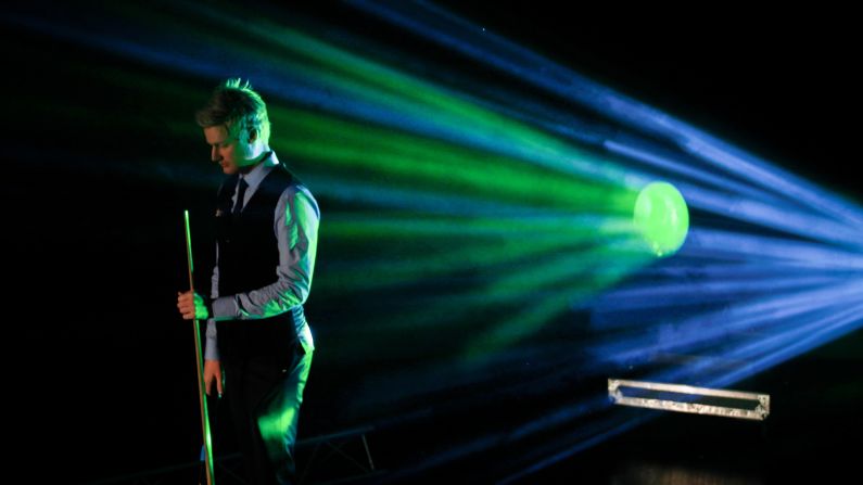 Colored light shines on snooker player Neil Robertson during the final match of the Champion of Champions event Sunday, November 15, in Coventry, England. Robertson defeated Mark Allen to win the tournament title.