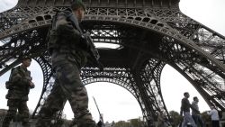 Soldiers patrol at the foot of the Eiffel Tower in Paris on November 16, 2015 three days after the terrorist attacks that left at least 129 dead and more than 350 injured. France prepared to fall silent at noon on November 16 to mourn victims of the Paris attacks after its warplanes pounded the Syrian stronghold of Islamic State, the jihadist group that has claimed responsibility for the slaughter. AFP PHOTO / KENZO TRIBOUILLARD        (Photo credit should read KENZO TRIBOUILLARD/AFP/Getty Images)