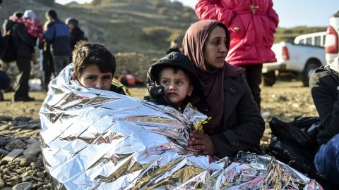 A Syrian family waits after arriving on the Greek island of Lesbos along with other migrants and refugees, on November 17, 2015.