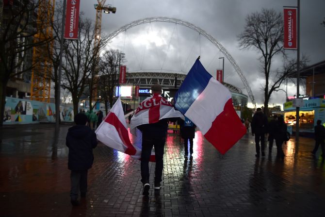 A supporter carries a French and an English flag as he makes his way towards Wembley before the game.
