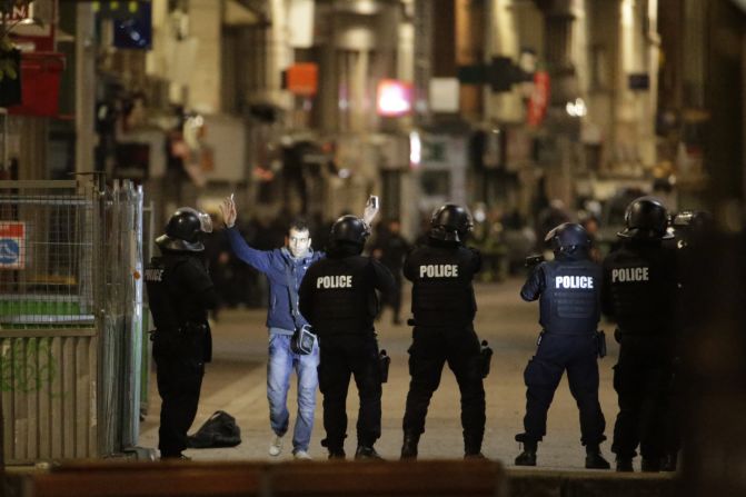 A man approaches a line of police officers during the raid.