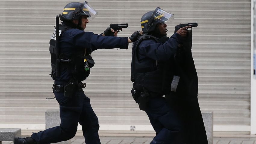 Armed police  operate in Saint-Denis, a northern suburb of Paris, Wednesday, Nov. 18, 2015. Police say two suspects in last week's Paris attacks, a man and a woman, have been killed in a police operation north of the capital. Two police officers have been injured in the standoff. Police have said the operation is targeting the suspected mastermind of last week's attacks, believed to be holed up in an apartment in Saint-Denis with several other heavily armed suspects. (AP Photo/Francois Mori)