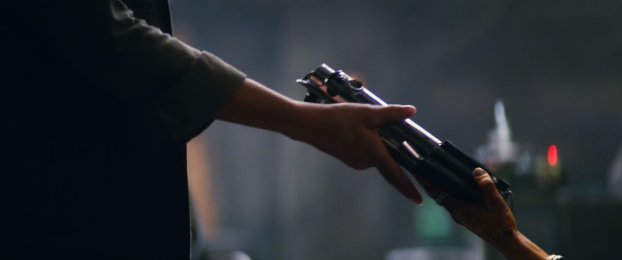 This shot from the official trailer shows a lightsaber changing hands, while Luke Skywalker, talking about the Force, says, "My sister has it." The lightsaber in question looks like Anakin's, which Luke inherits in Episode IV. So who's getting it? Well, we think they're female hands. Is that Leia gaining custody of her brother's weapon? Or is she passing it on to Rey? Are there any other female characters around that we haven't seen yet?