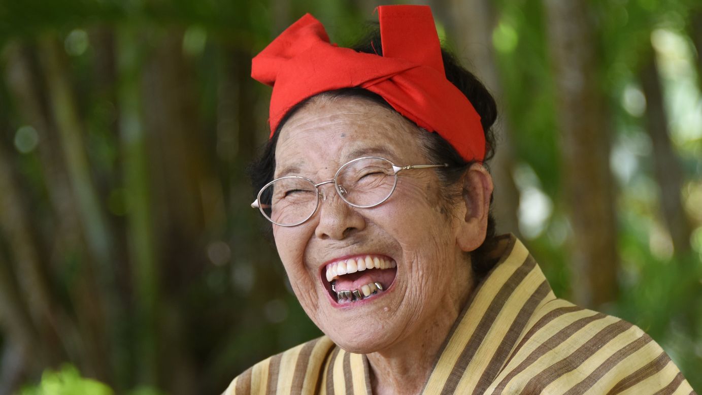 Tomi Menaka, a 92-year-old member of a singing and dancing troupe, laughs during a performance on Japan's Kohama Island on Monday, June 22.
