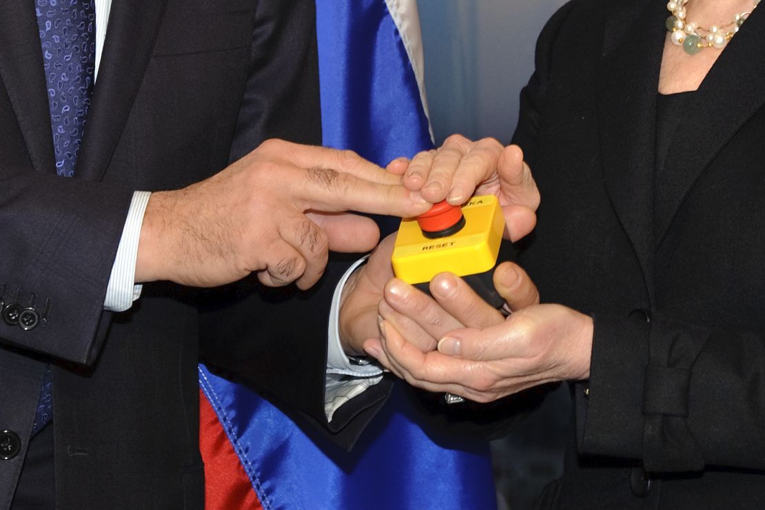 The hands of US Secretary of State Hillary Clinton and Russian Foreign Minister Sergei Lavrov rest on a red button marked "reset" in English and "overload" in Russian that US Secretary of State Hillary Clinton handed to Russian Foreign Minister Sergei Lavrov during a meeting in March  2009.