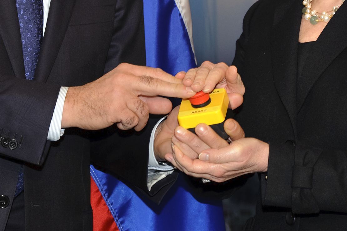 The hands of US Secretary of State Hillary Clinton and Russian Foreign Minister Sergei Lavrov rest on a red button marked "reset" in English and "overload" in Russian that US Secretary of State Hillary Clinton handed to Russian Foreign Minister Sergei Lavrov during a meeting in March 2009.