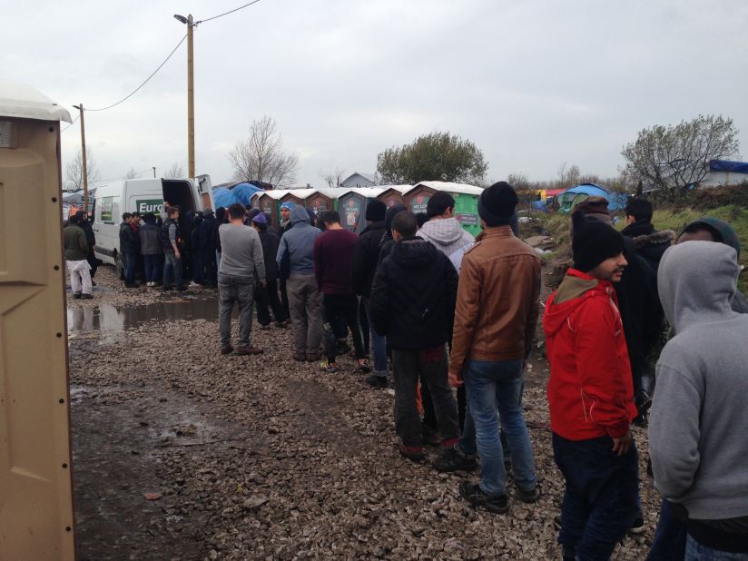 The queue for food aid stretches far in the Jungle. Volunteers, who are often from England, hand out melons, apples and bread.