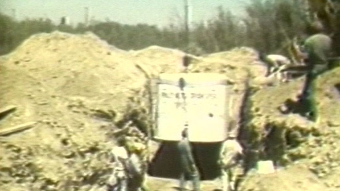 Workers excavate the buried moving van where 27 hostages were trapped.