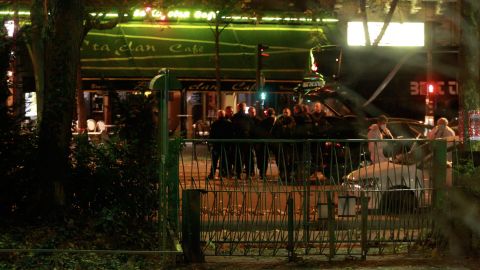 Officials investigate the scene outside the concert hall where dozens were killed.