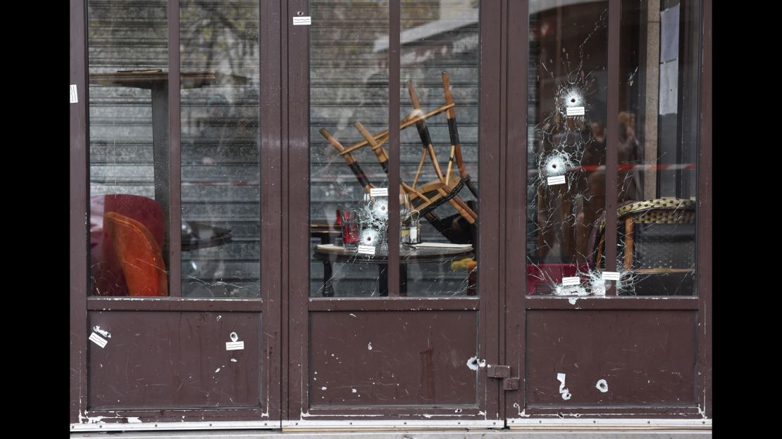 Bullet holes in the Café Bonne Bière storefront are a reminder of the carnage.
