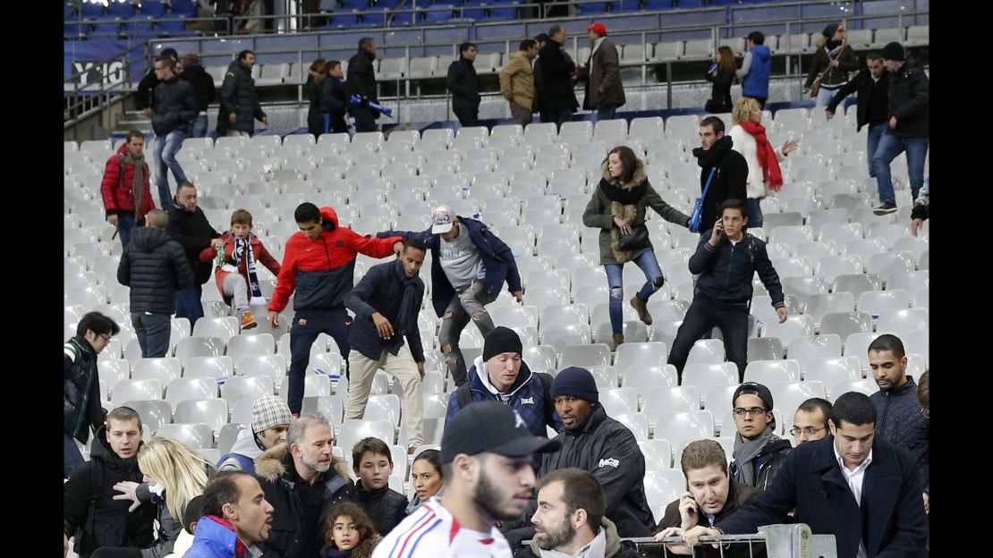 Fans climb down the seats of the Stade de France after the match.