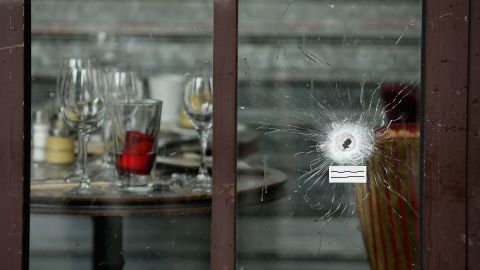 Bullets holes are seen through the glass door of a cafe near Casa Nostra.