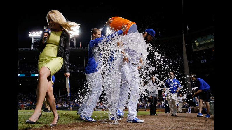 Television reporter Kelly Crull runs away from the scene as Chicago Cubs pitcher Jake Arrieta is doused by his teammates after his 20th win of the season on Tuesday, September 22. Arrieta finished with 22 wins in the regular season and won the National League's Cy Young Award.