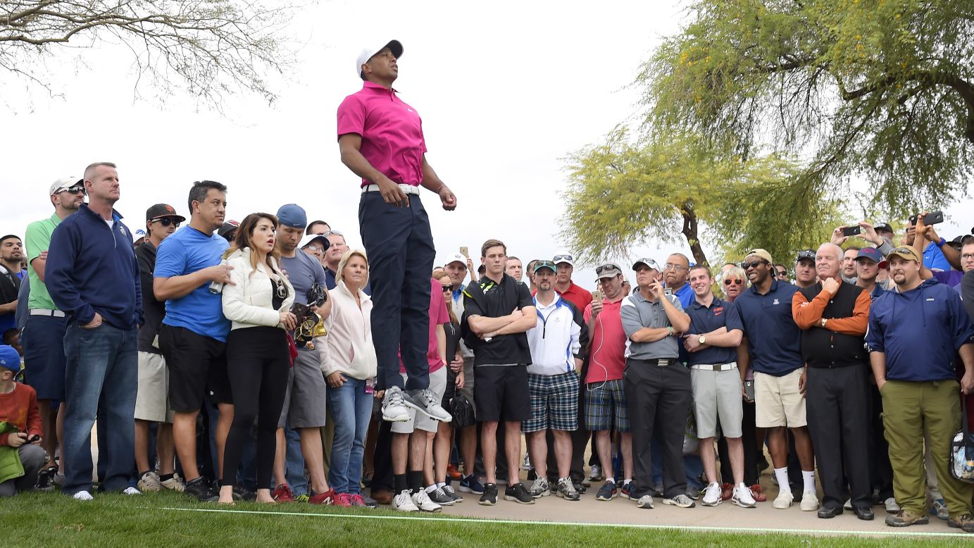 Tiger Woods leaps above the gallery to see the eighth green during the first round of the Phoenix Open on Thursday, January 29.