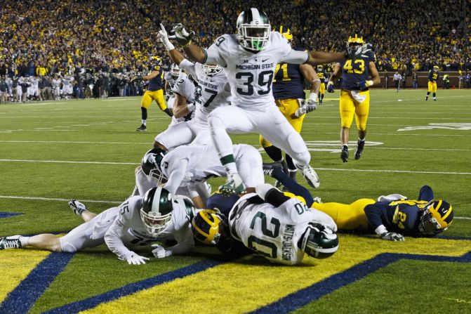Michigan State players crash into the end zone after Jalen Watts-Jackson scored an improbable touchdown to defeat Michigan on Saturday, October 17. Michigan looked to have the game in hand until fumbling on a punt play with 10 seconds left. Watts-Jackson <a href="index.php?page=&url=http%3A%2F%2Fbleacherreport.com%2Farticles%2F2580146-michigan-state-wins-on-walk-off-td-after-michigan-punter-fumbles-on-final-play" target="_blank" target="_blank">returned the ball</a> for a 27-23 victory.