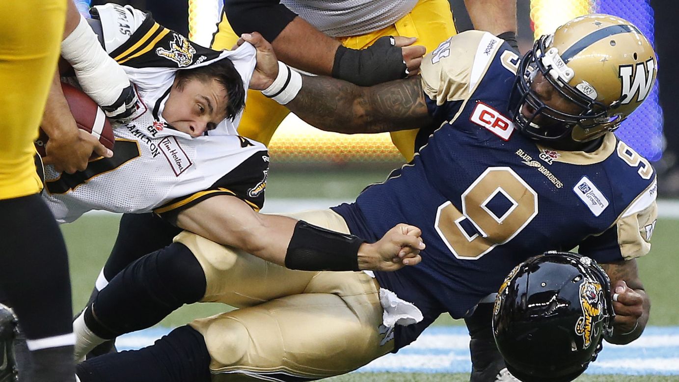 Winnipeg's Thaddeus Gibson, right, tackles Hamilton quarterback Zach Collaros during a Canadian Football League game Friday, June 19, in Winnipeg, Manitoba. Gibson received a penalty for ripping off Collaros' helmet.