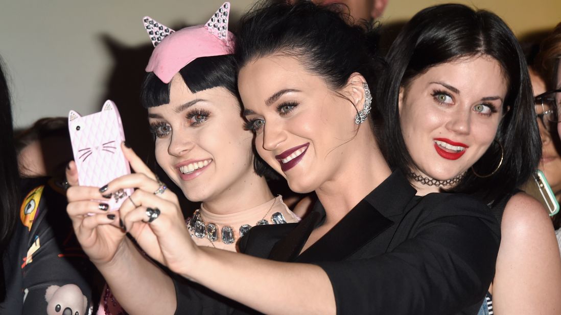 Singer Katy Perry, center, takes a selfie with lookalike fans on Thursday, March 26, at a Los Angeles screening of her concert video "Katy Perry: The Prismatic World Tour."