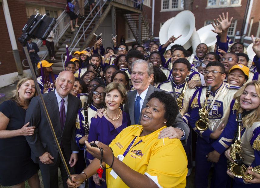 Former U.S. President George W. Bush and his wife, Laura, pose for a selfie with members of a high school band in New Orleans on Friday, August 28.