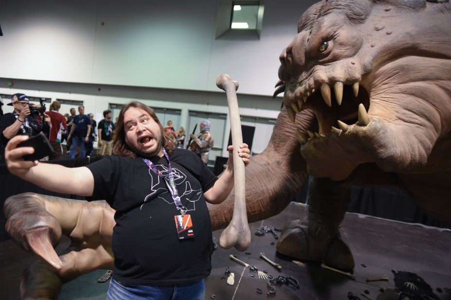 A "Star Wars" fan takes a selfie with a rancor exhibit at a fan experience in Anaheim, California, on Thursday, April 16.
