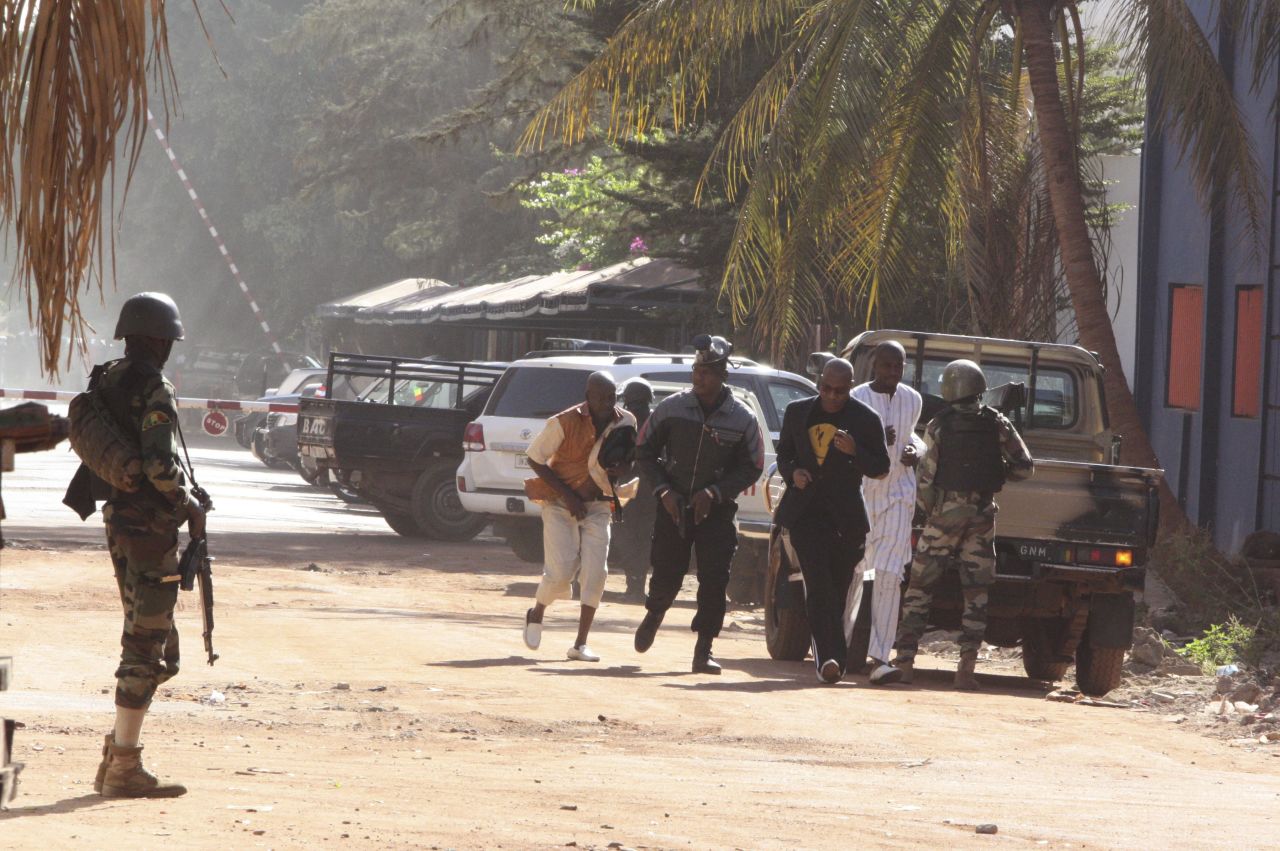 Security forces help people flee the hotel on November 20.
