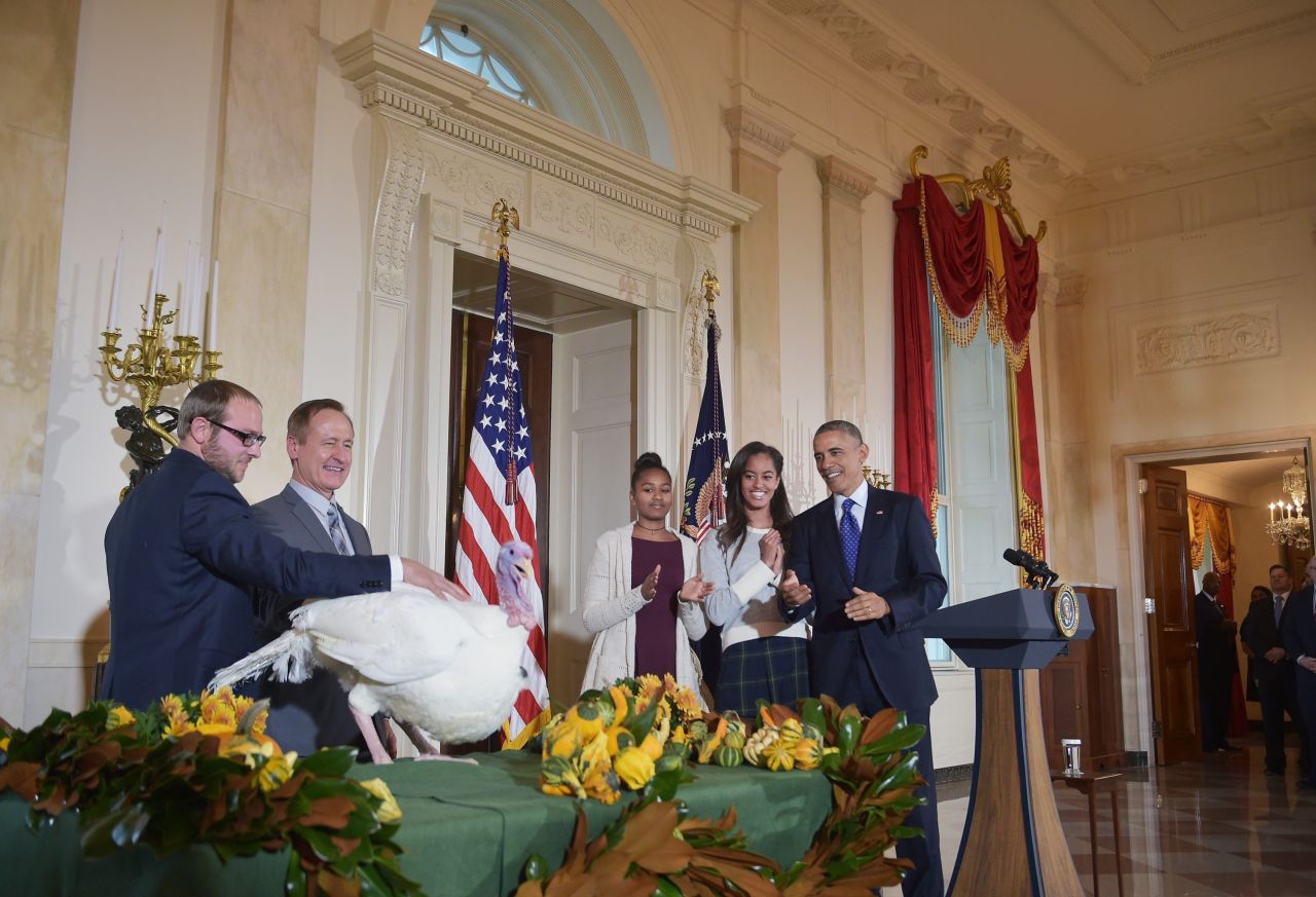 Obama and his daughters, Sasha and Malia, applaud Cheese, the national Thanksgiving turkey, in 2014.