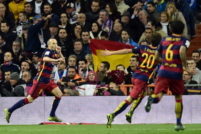 Barcelona midfielder Andres Iniesta (L) celebrates scoring his side's third goal in the El Clasico fixture.