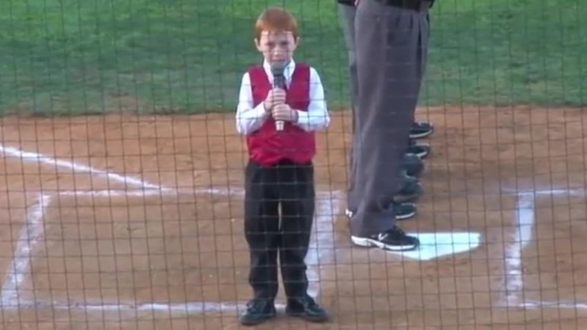 A young boy receives congratulations from all after he delivers a stunning rendition of Australia's national anthem while battling an onset of hiccups.