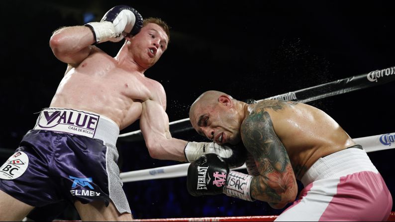 Canelo Alvarez punches Miguel Cotto during their middleweight title fight in Las Vegas on Saturday, November 21. Alvarez won by unanimous decision, improving his record to 46-1-1.