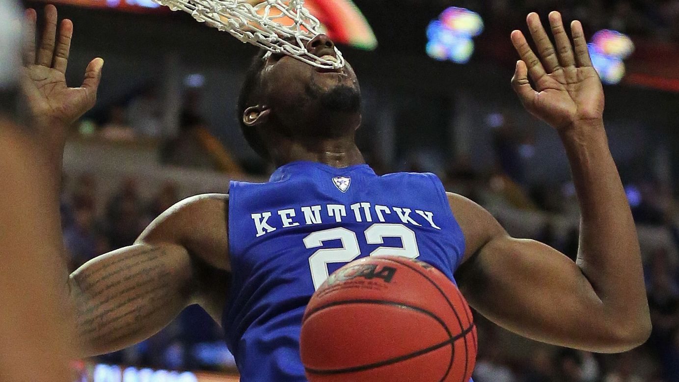Kentucky's Alex Poythress gets his teeth caught in the net after dunking against Duke in Chicago on Tuesday, November 17.