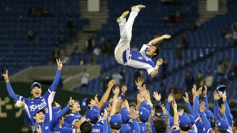 South Korea second baseman Jeong Keun-woo is tossed into the air by teammates after they defeated the United States 8-0 in the final of the inaugural Premier 12 baseball tournament, which was played in Tokyo on Saturday, November 21.