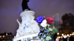 Мъж държи рози в цветовете на френското национално знаме на Place de la Republique (Площада на републиката) в Париж на 21 ноември 2015 г., докато пристига да отдаде почит на жертвите на терористичните атаки от 13 ноември.  Координирана вълна от атаки срещу нощни заведения в Париж, поети от джихадистите от групировката "Ислямска държава" (ИД), убиха 130 души.
