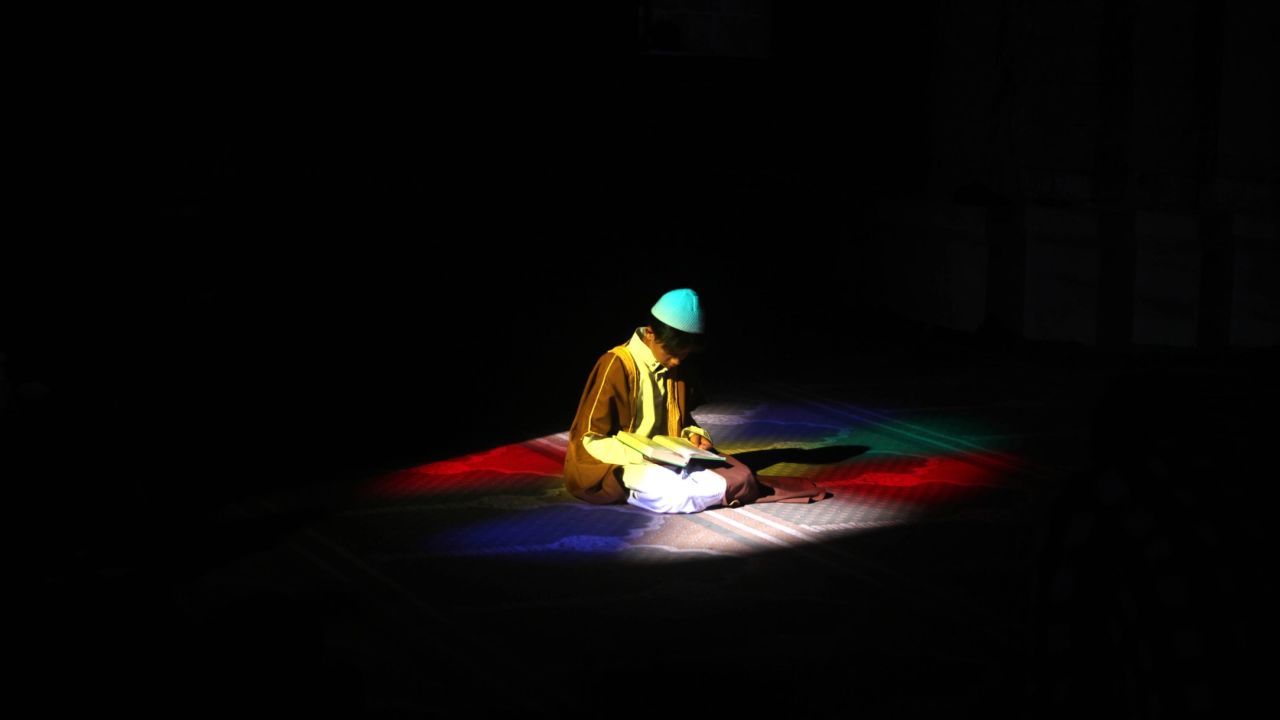 <strong>June 19:</strong> During the holy month of Ramadan, a Palestinian boy reads the Quran at a mosque in Gaza City.