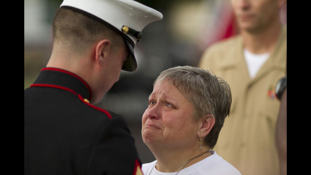 <strong>July 21: </strong>Cathy Wells, mother of Lance Cpl. Squire K. "Skip" Wells, is given flowers by a U.S. Marine at her son's vigil in Marietta, Georgia. Wells, a 21-year-old reservist, was one of five service members killed during <a href="http://www.cnn.com/2015/07/16/us/gallery/chattanooga-tennessee-shooting/index.html" target="_blank">a shooting at a Navy reserve center</a> in Chattanooga, Tennessee. The shooter, Mohammad Abdulazeez, died in a gunfight with law enforcement. He had also shot up a military recruiting center before driving to the reserve center.