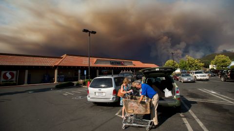 <strong>August 2:</strong> Shoppers load groceries as smoke from the Rocky Fire billows over Clearlake, California. California <a href="http://www.cnn.com/2015/07/18/us/gallery/ca-wildfire-2015/index.html" target="_blank">has been battling numerous wildfires</a> as its historic drought reaches a fourth year.