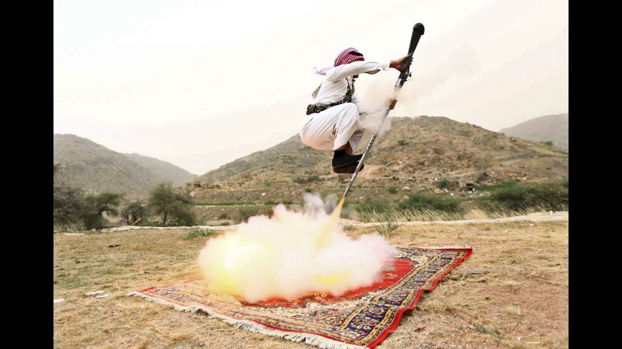 <strong>August 8:</strong> A man fires a weapon as he dances during a traditional celebration near Taif, Saudi Arabia.
