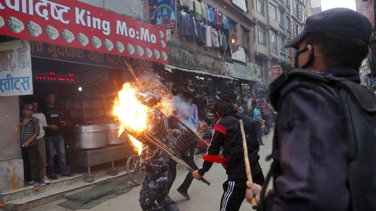 <strong>August 15:</strong> Protesters hit a police officer with a torch during a rally in Kathmandu, Nepal. There were <a href="http://www.cnn.com/2015/08/25/asia/nepal-police-protester-deaths/" target="_blank">violent clashes</a> over the country's <a href="http://www.cnn.com/2015/09/20/asia/nepal-new-constitution-explainer/" target="_blank">proposals for a new constitution,</a> and some police officers were killed or injured. The officer in this photo was injured, according to the photographer, but he survived.