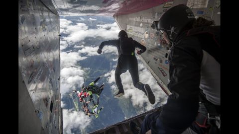 <strong>August 27:</strong> People jump out of a plane during the Mountain Gravity skydiving competition in Quinto, Switzerland.