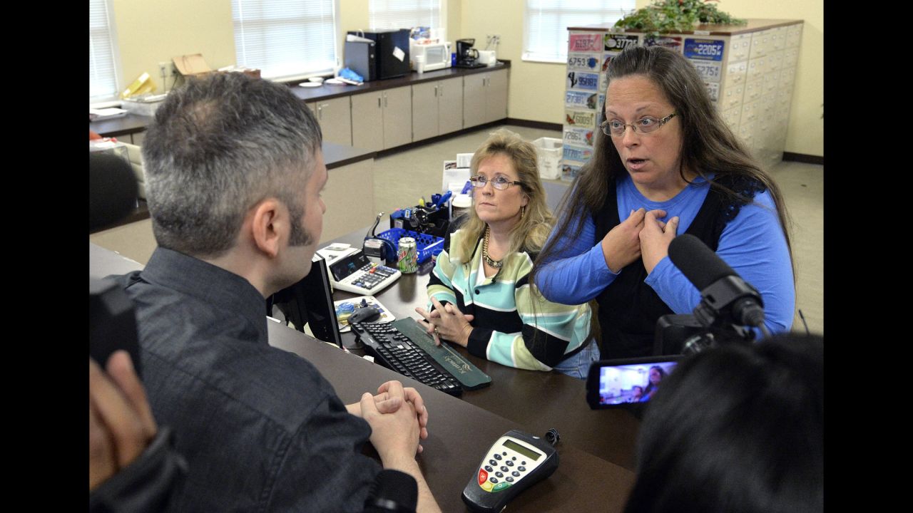 <strong>September 1:</strong> Rowan County Clerk Kim Davis, right, talks with David Moore after she refused him a marriage license in Morehead, Kentucky. Davis was eventually jailed for <a href="http://www.cnn.com/2015/09/14/politics/kim-davis-same-sex-marriage-kentucky/index.html" target="_blank">refusing to issue marriage licenses to same-sex couples.</a> She said same-sex marriages violated her Christian beliefs. After her release, she said she would not issue any marriage licenses that go against her religious beliefs. But she left the door open for her deputies to give out marriage licenses to same-sex couples as long as those documents do not have her name or title on them.